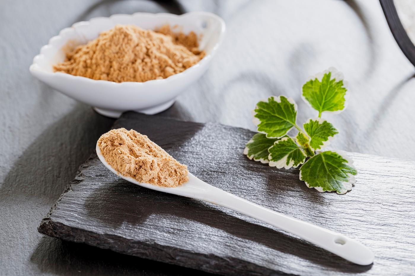 Maca root powder on a spoon and in a bowl