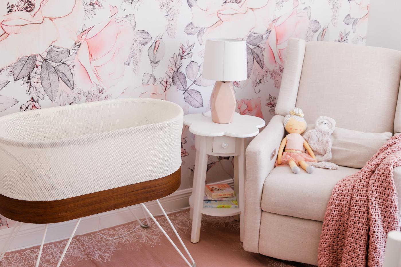 A pink and purple floral nursery with a SNOO