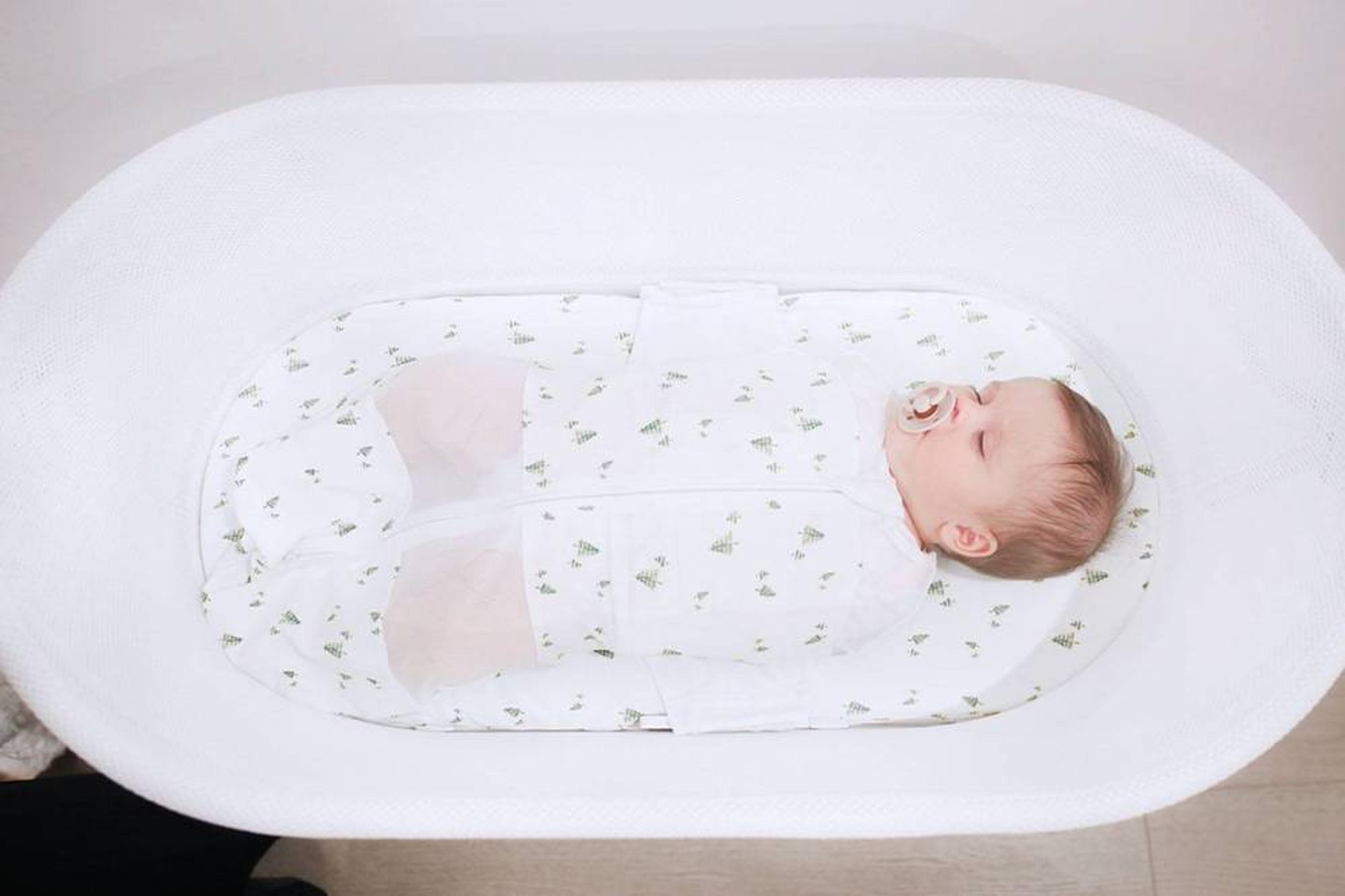 Baby sleeping in SNOO, a rocking bassinet 