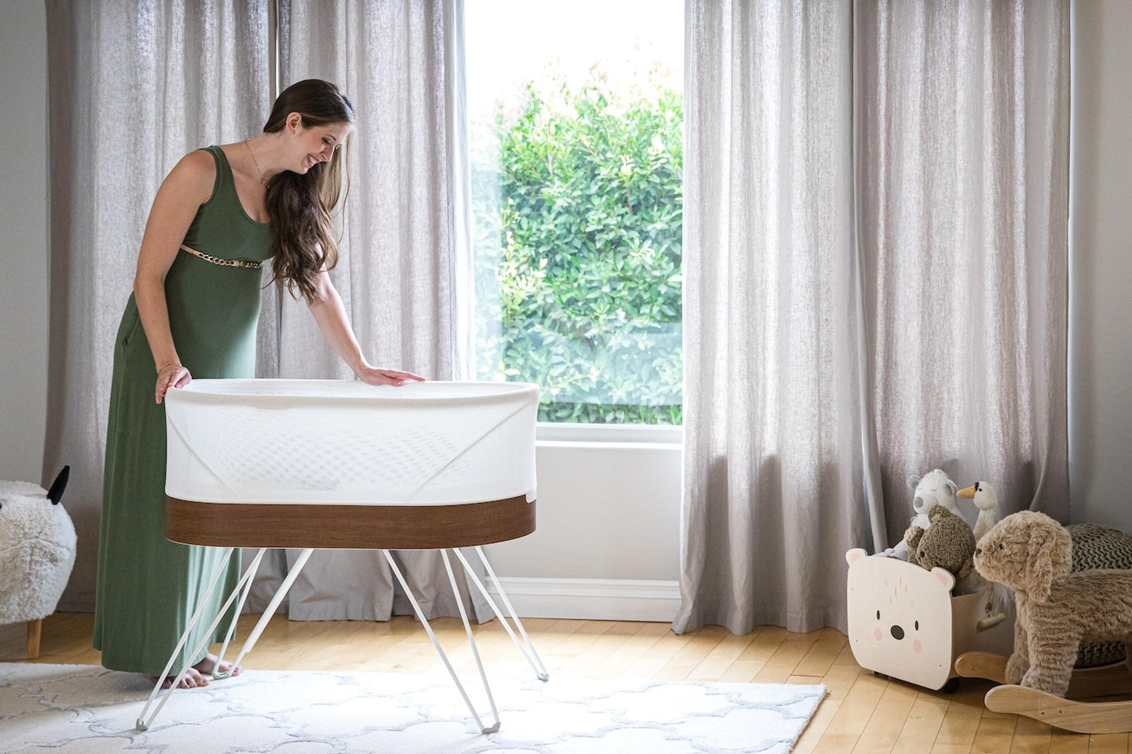 Expecting mother sets up SNOO Smart Sleeper in her nursery