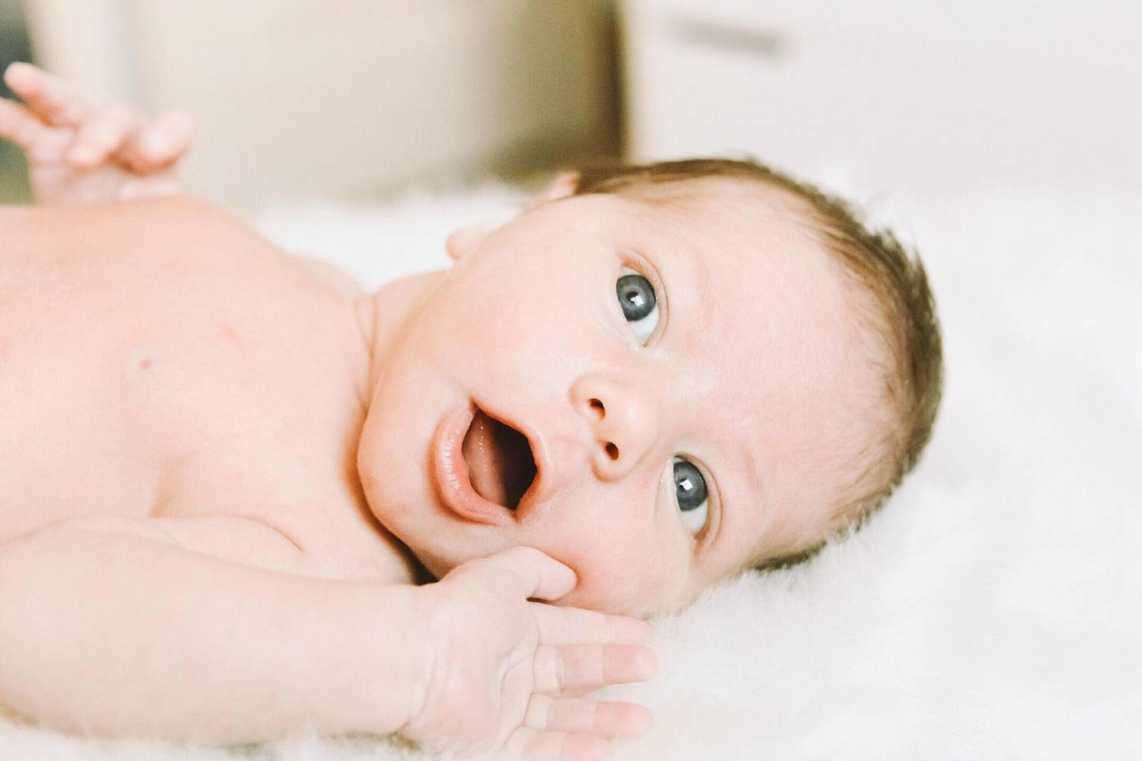 A 2-week-old baby lays on his back