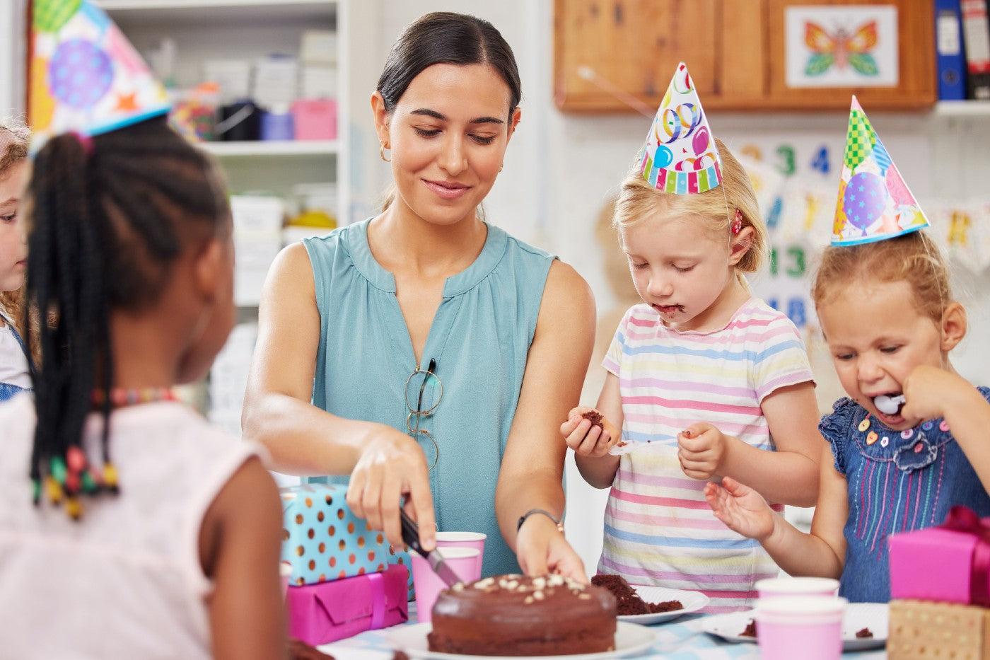 A mom cuts the cake at a kid's birthday party