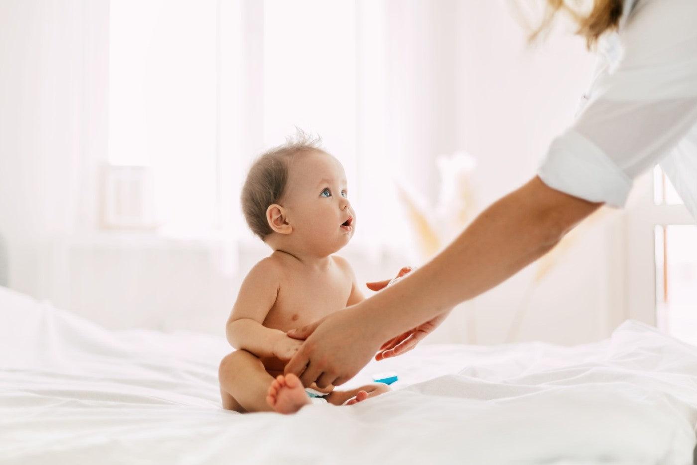Baby sitting up for the first time with Mom's help