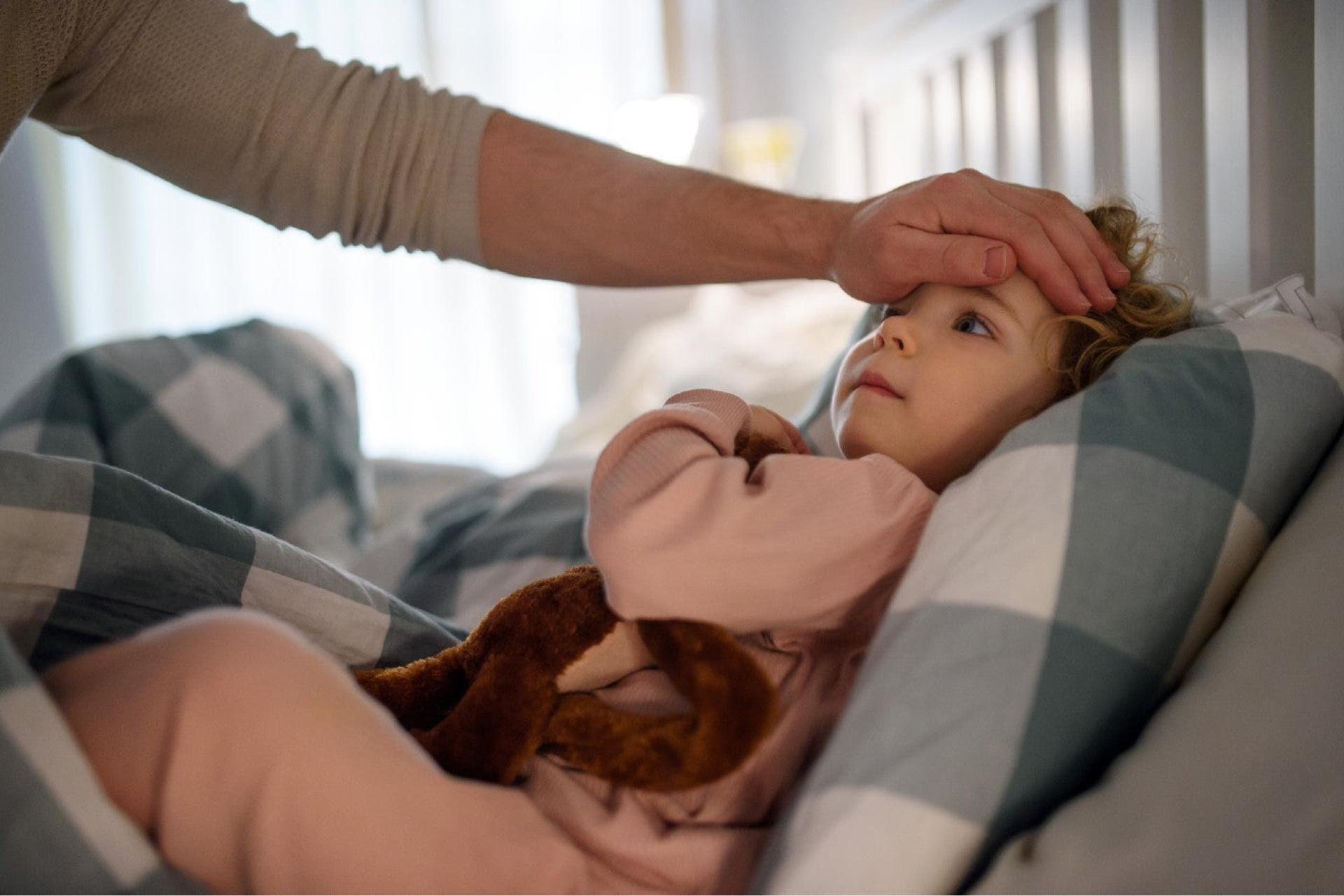 Parents feeling child's head for fever