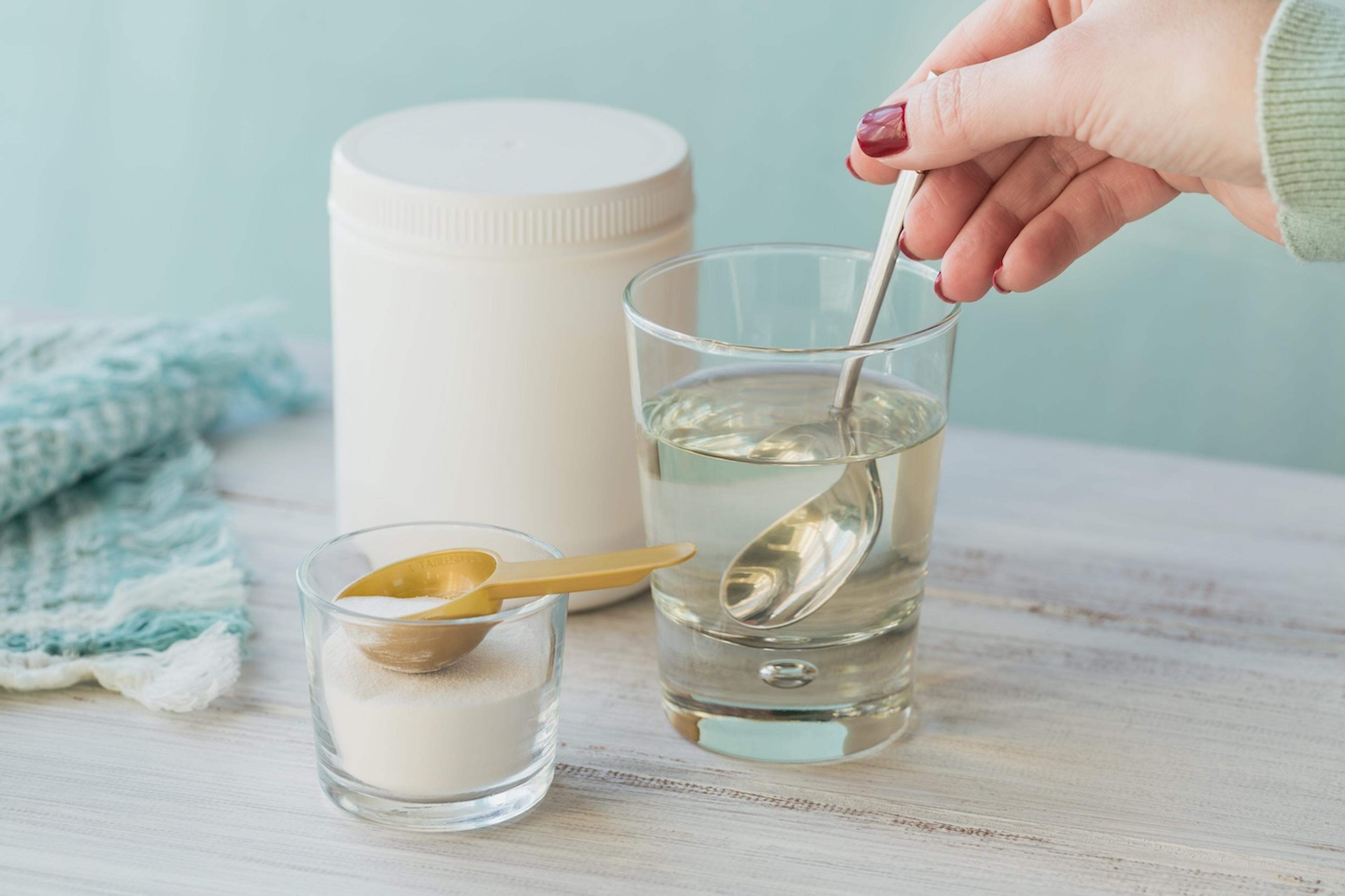 Woman stirring collagen powder into water