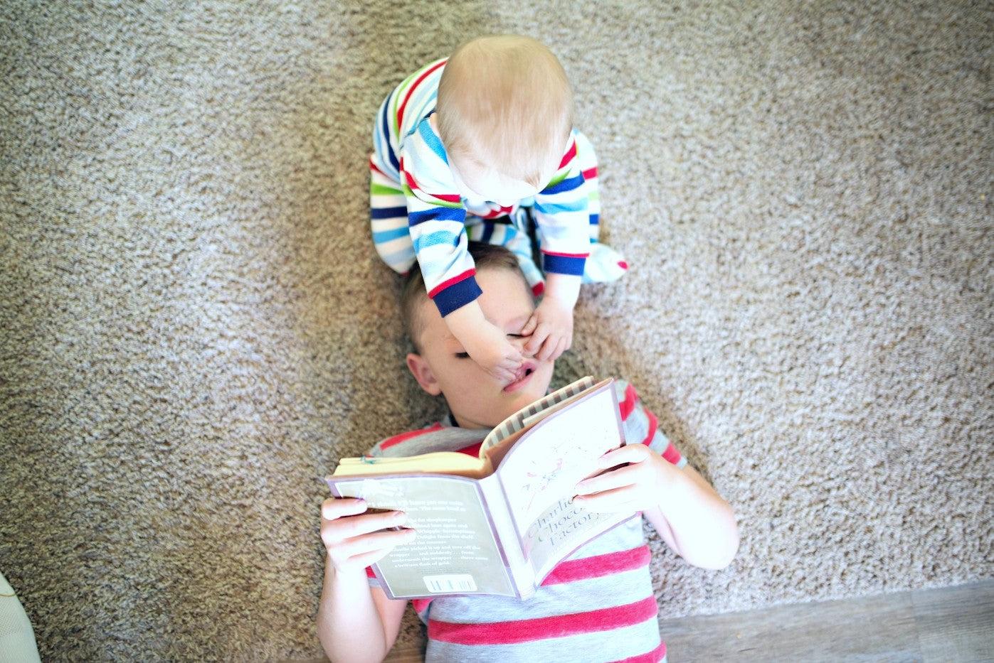 Baby pinching and bothering older brother