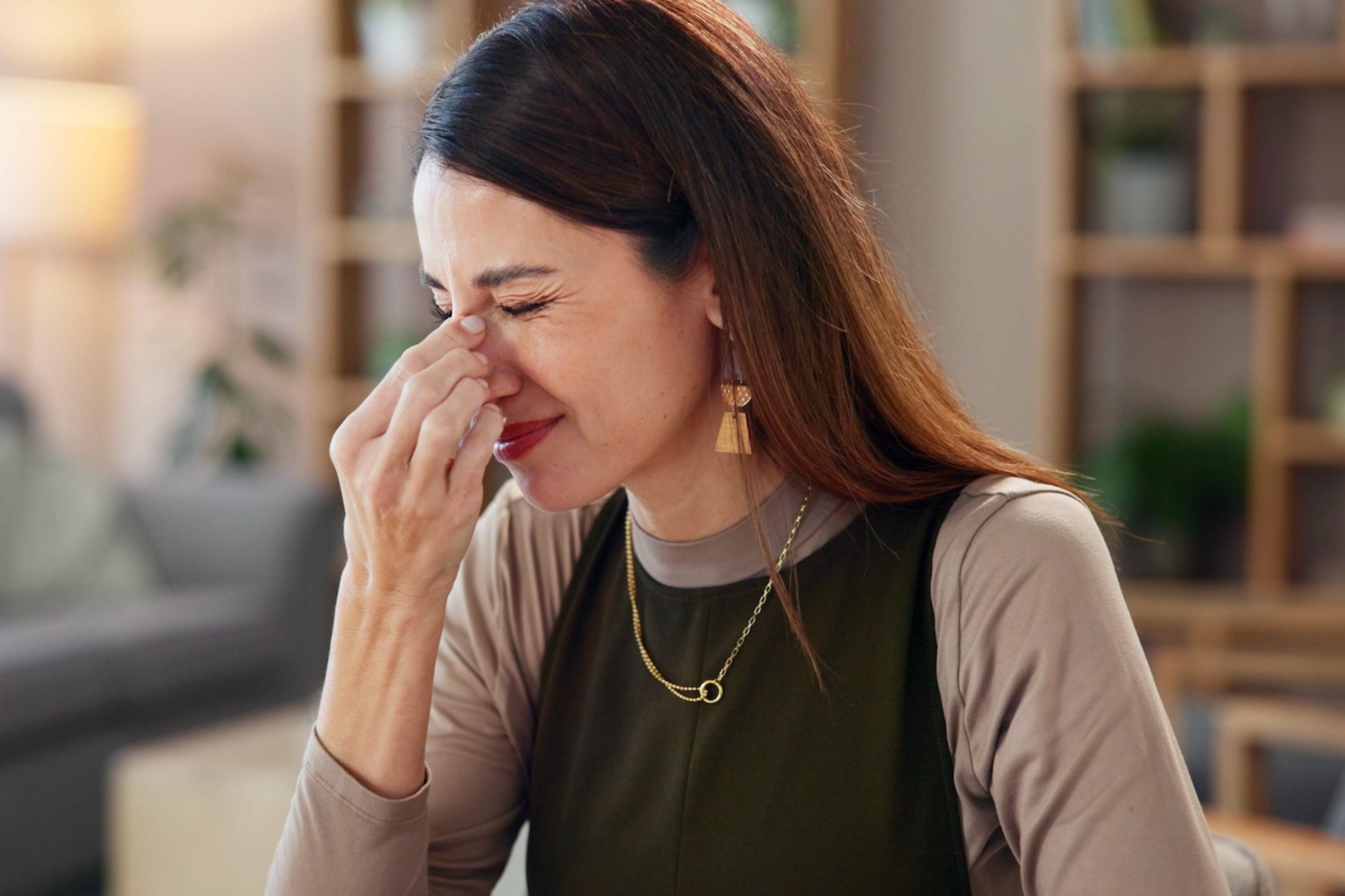 A pregnant woman pinches her nose after smelling something unpleasant