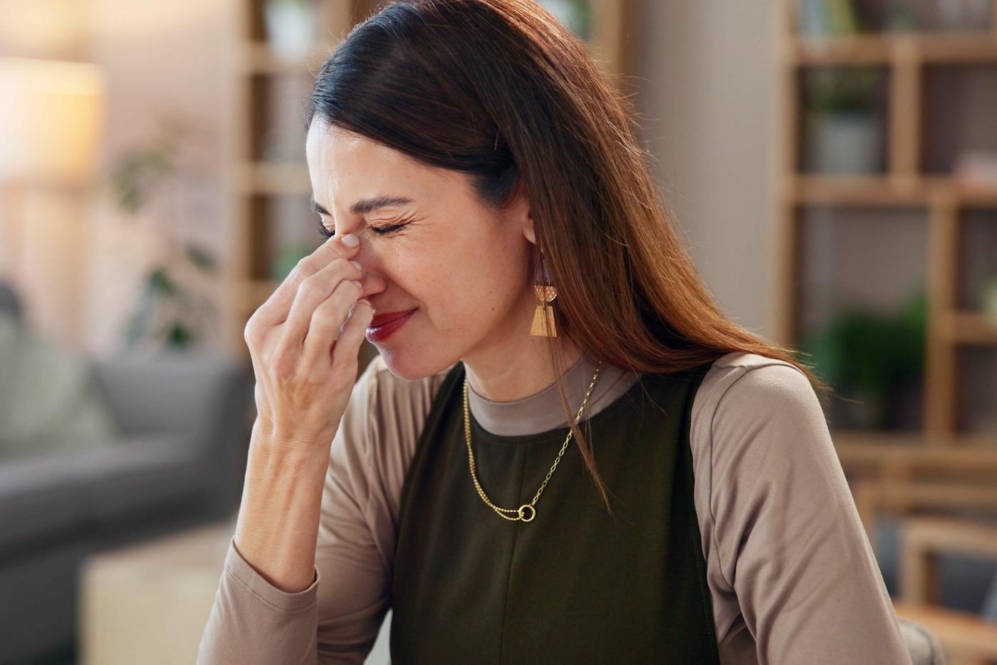 A pregnant woman pinches her nose after smelling something unpleasant