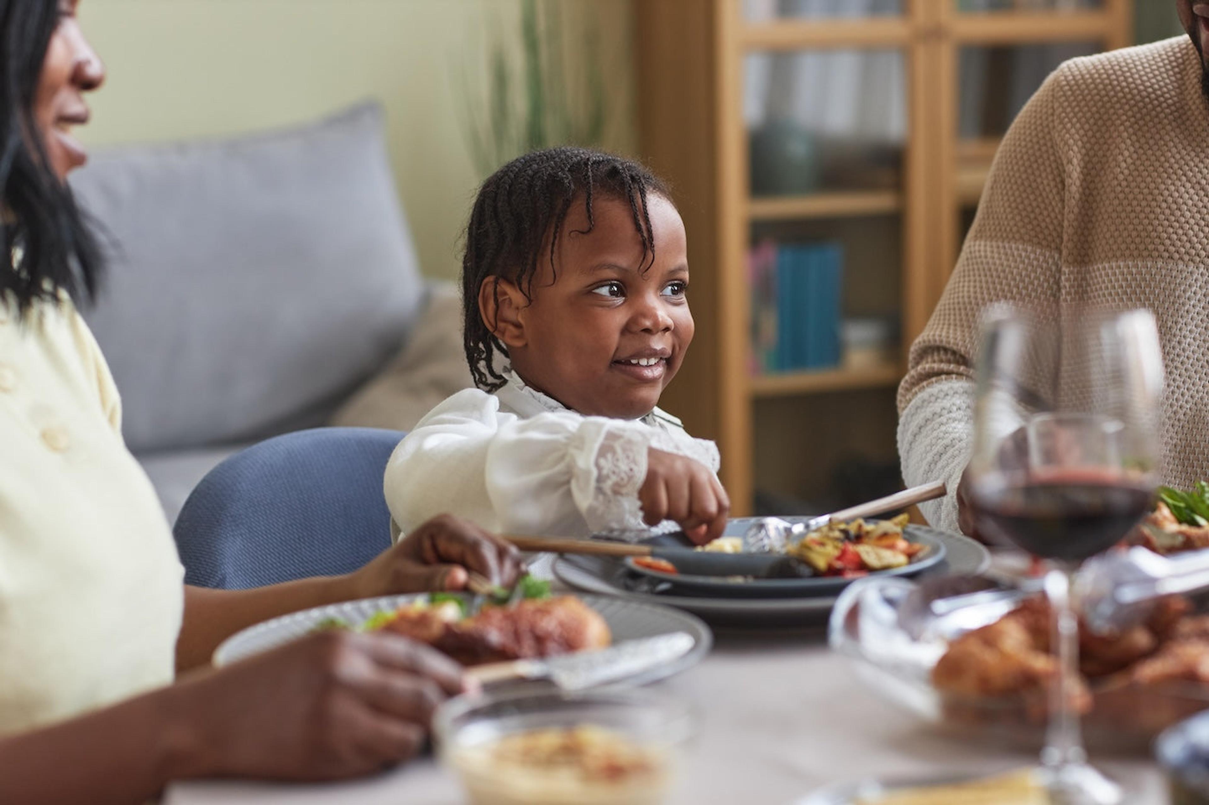 A toddler eats at the dinner table