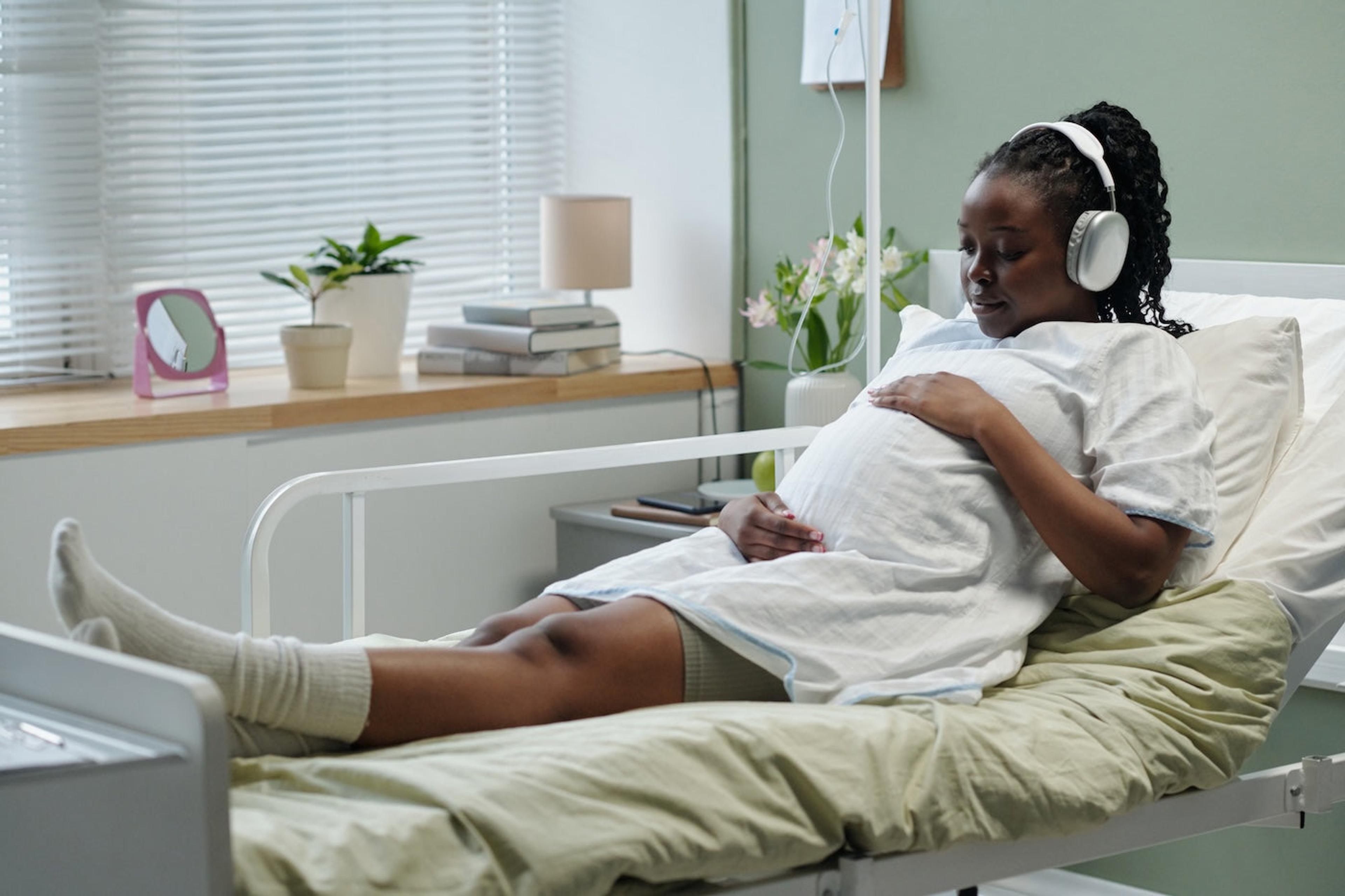 A woman wearing headphones listens to music during labor