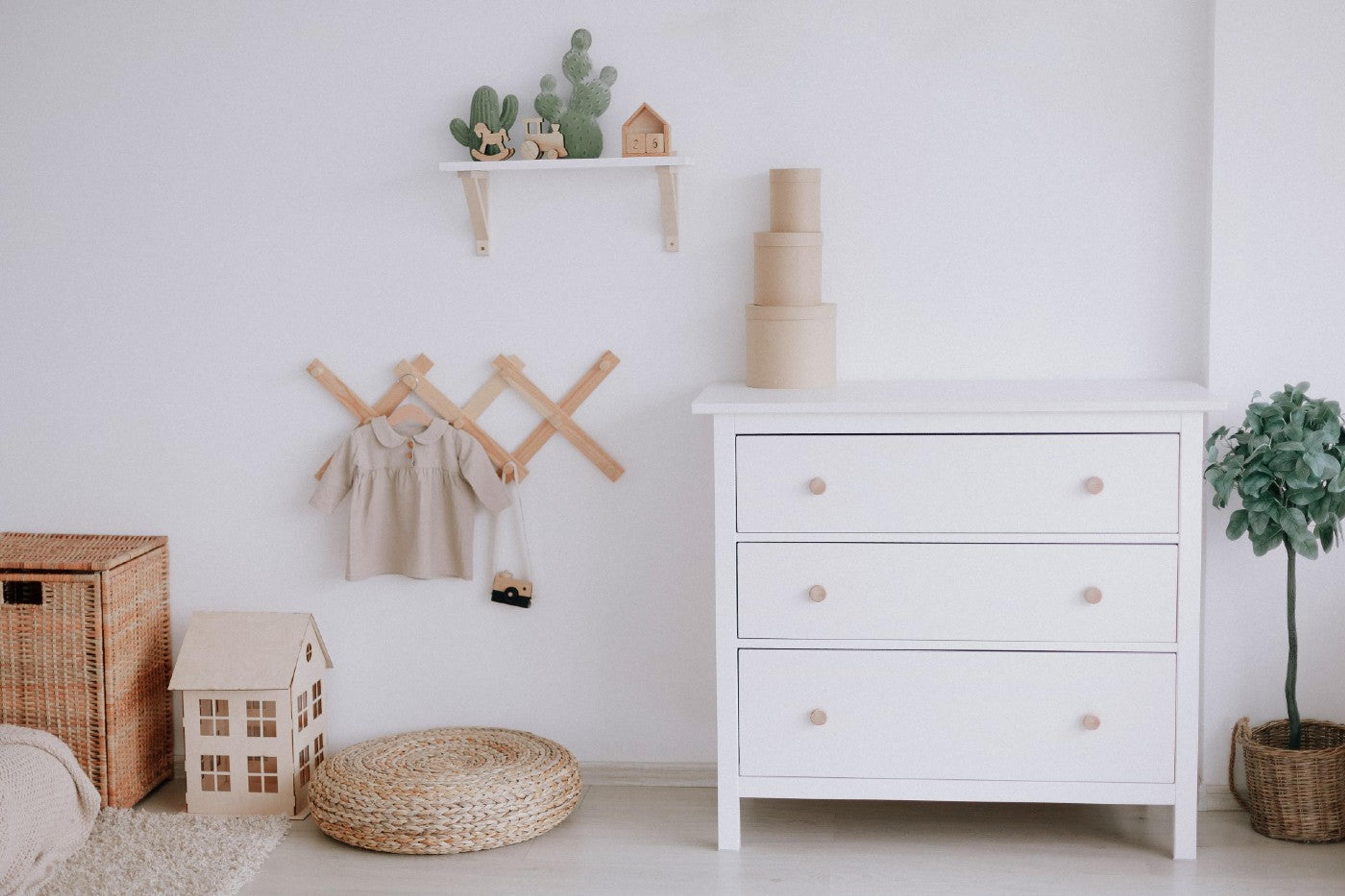 Feng Shui nursery design featuring a white dresser, floating shelves, and a plant