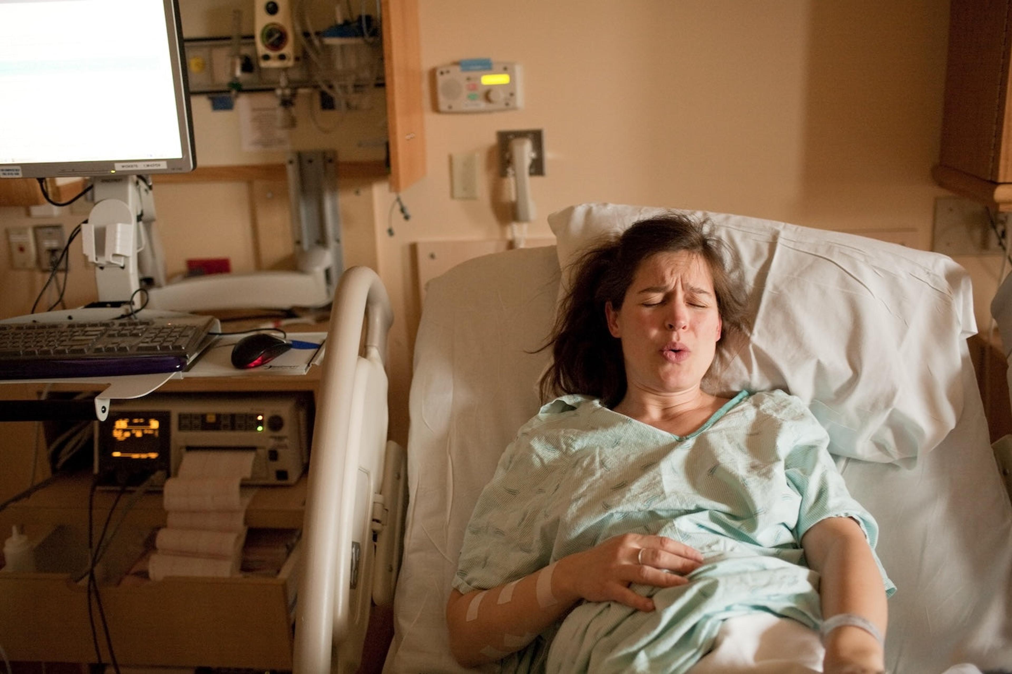 A pregnant woman manages labor pain from her hospital bed