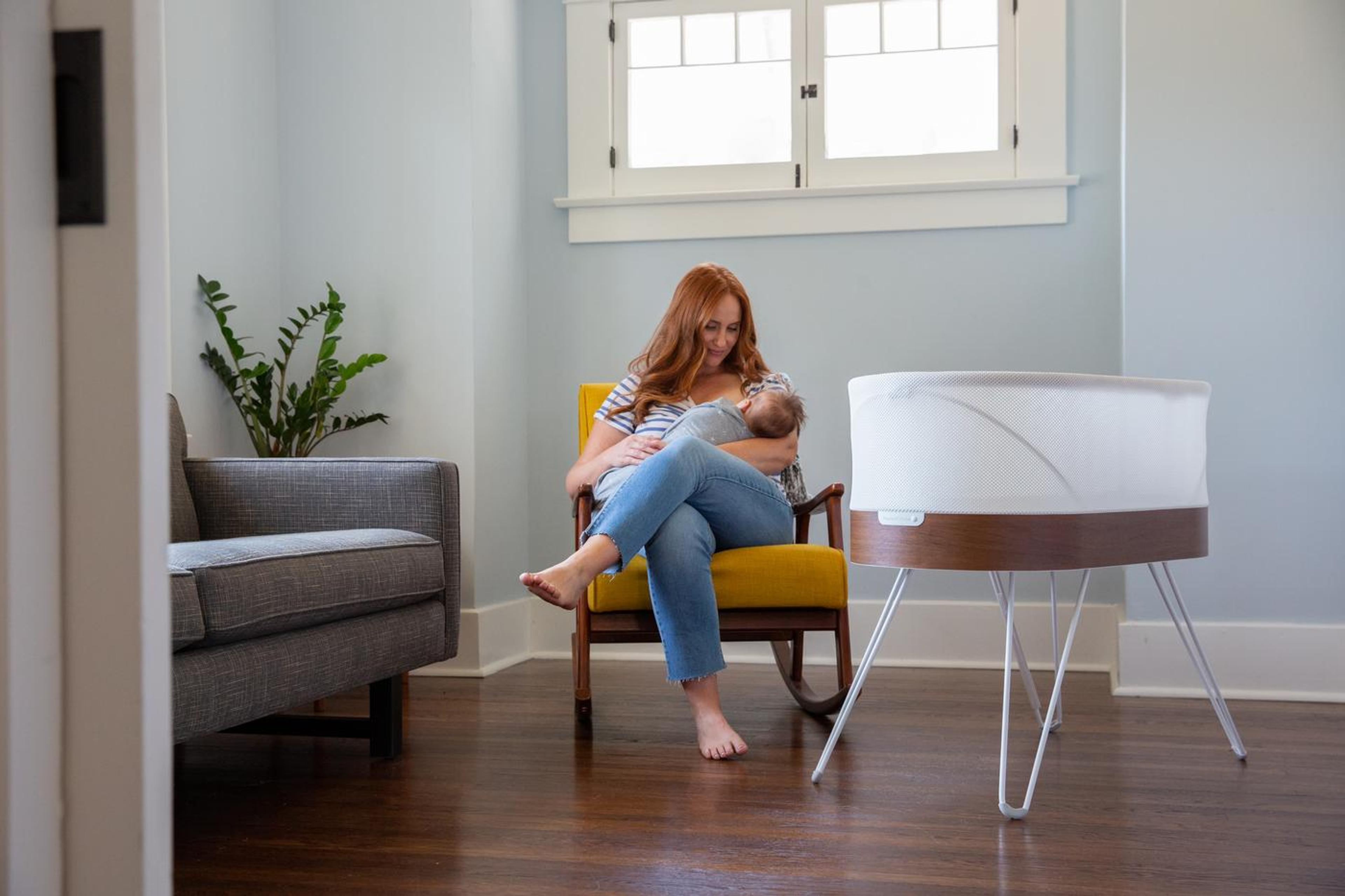Mom breastfeeding infant next to SNOO