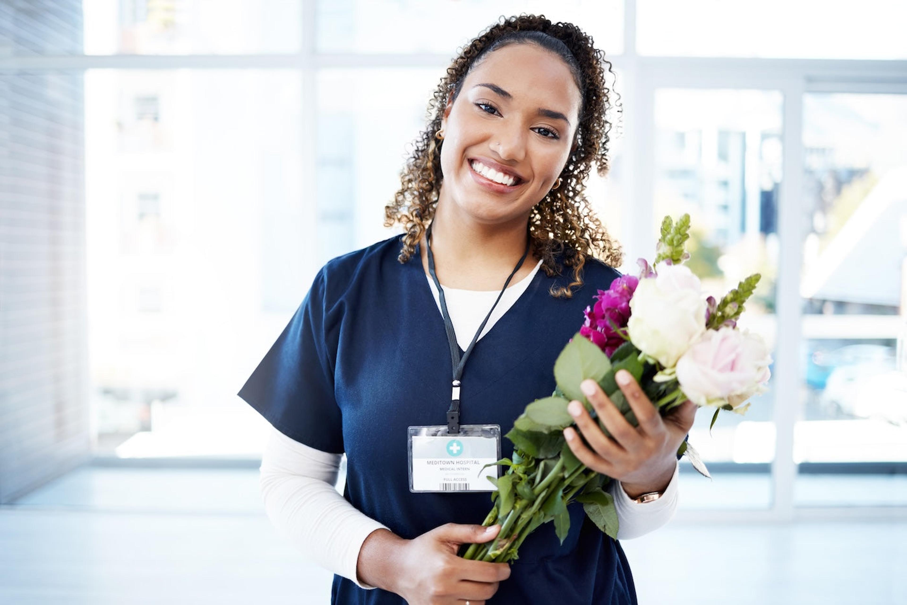 A labor and delivery nurse holds a bouquet of flowers she received as a nurse thank you gift