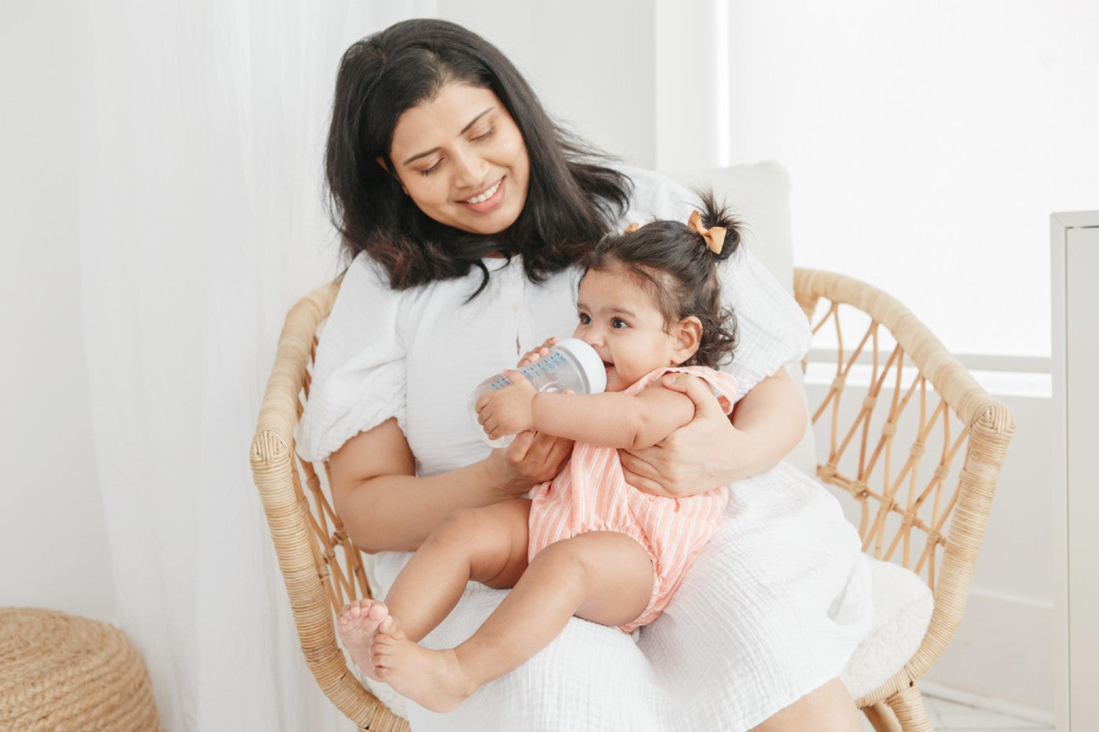 A mother feeds her baby with a bottle