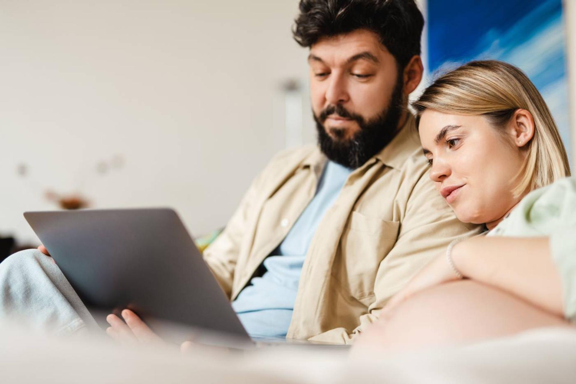 A couple makes a birth plan on a laptop