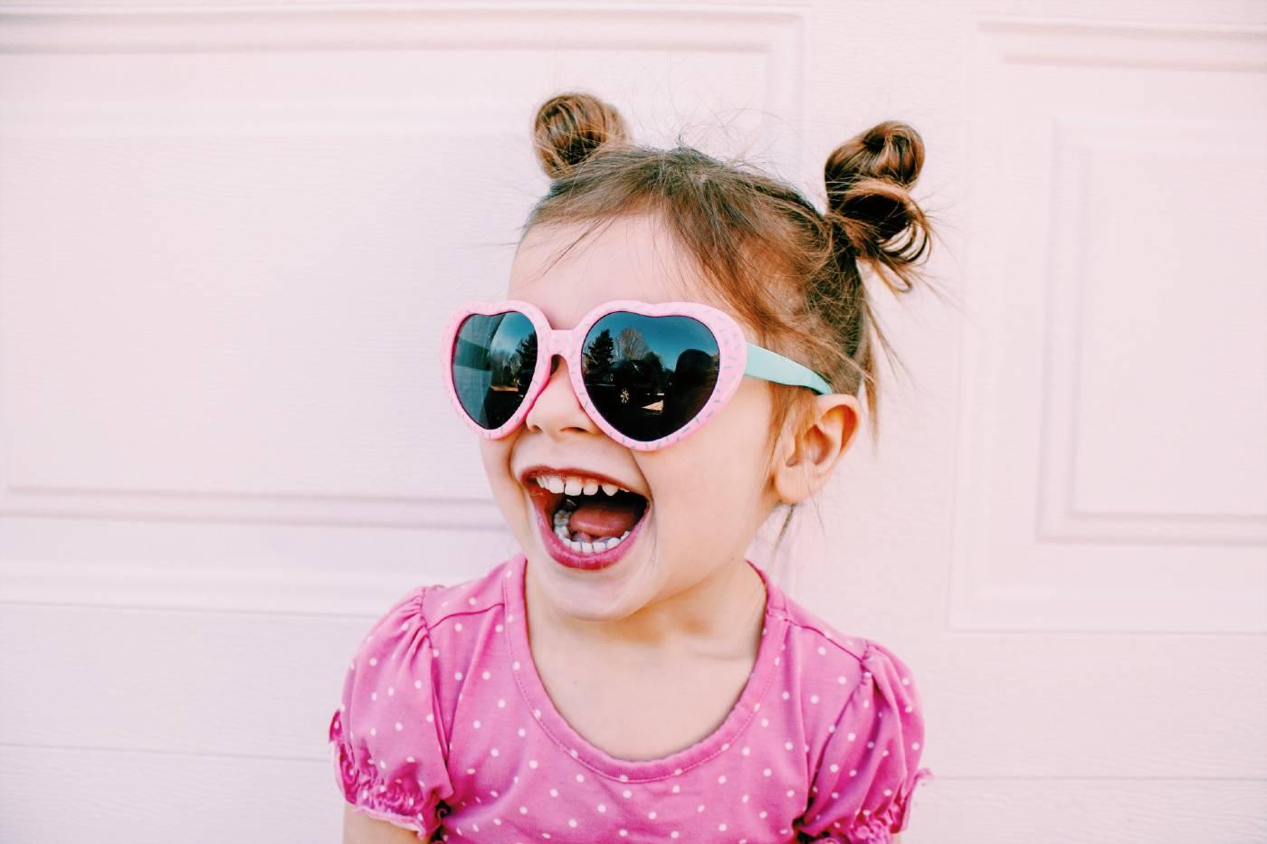 Happy toddler wearing heart-shaped sunglasses