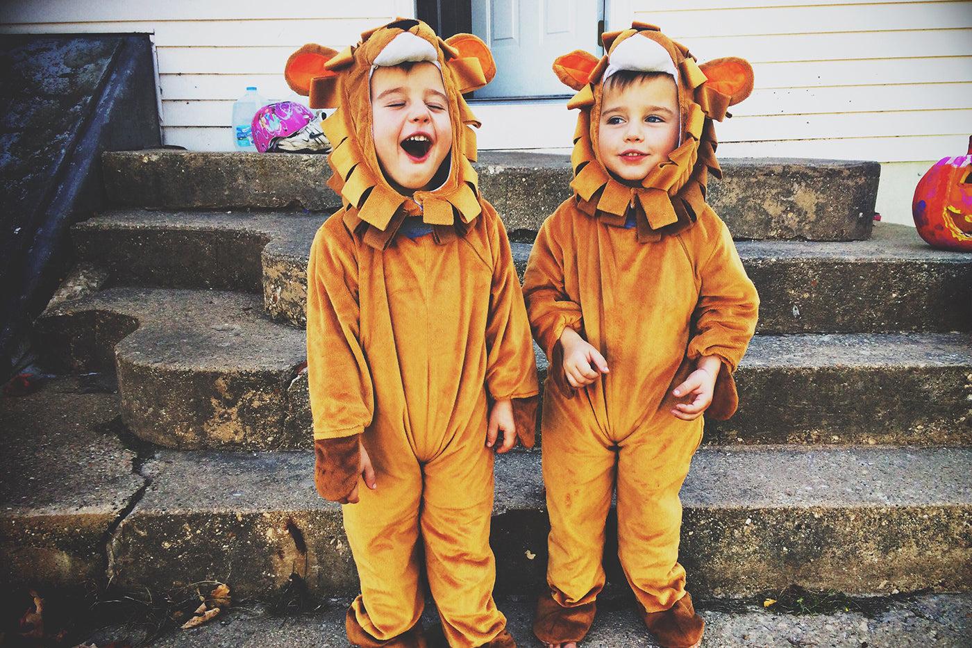 Toddlers in matching lion halloween costumes