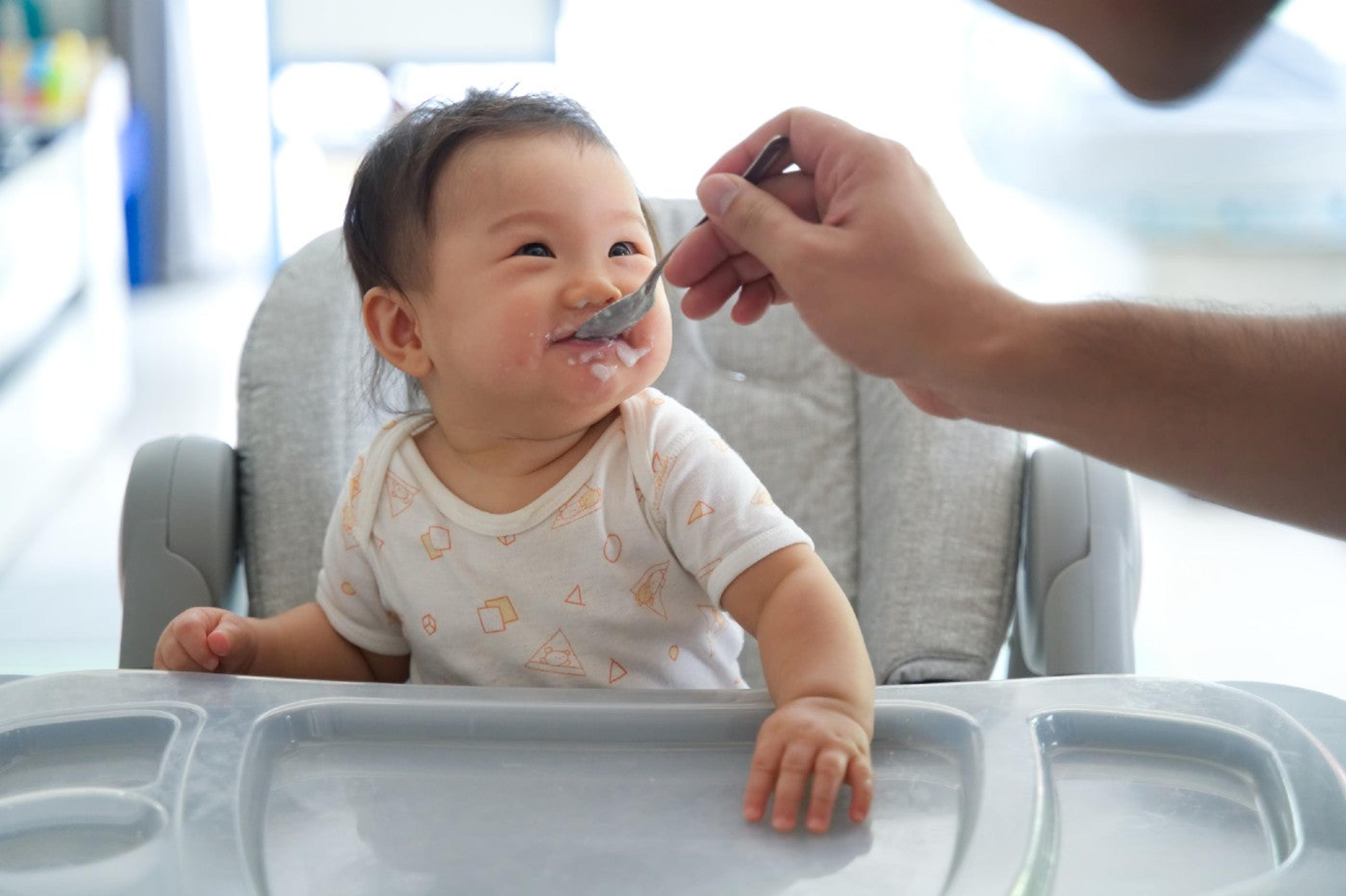 A father feeds a baby oatmeal