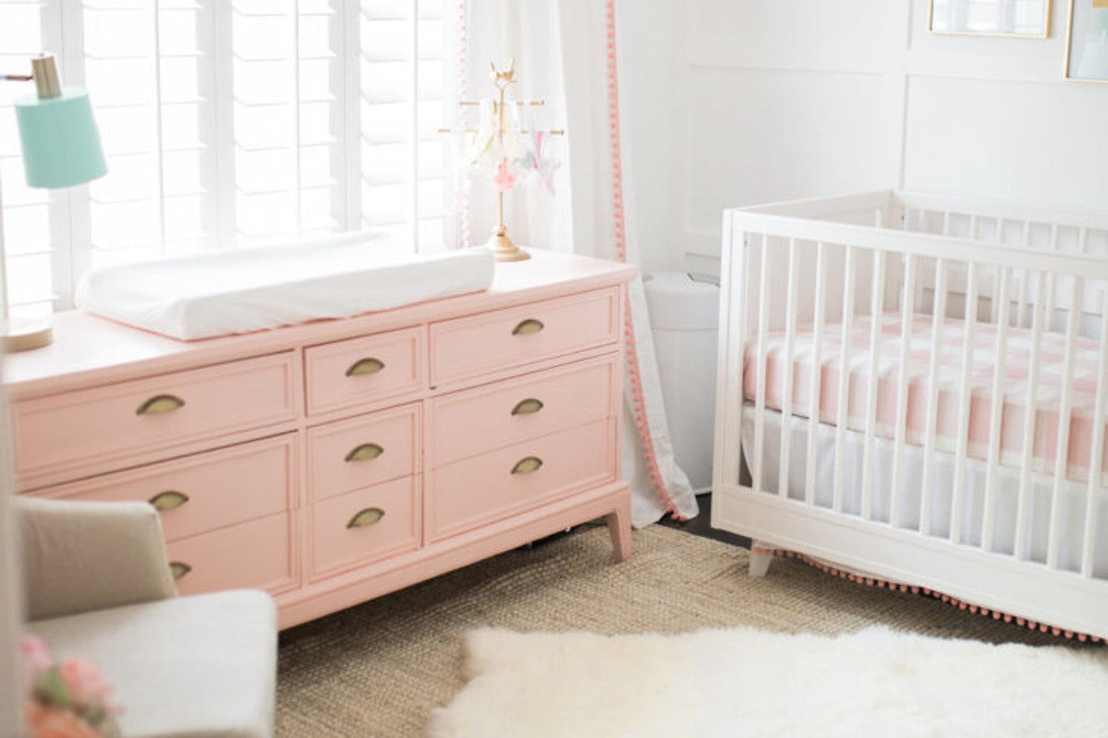 Nursery with a pink painted dresser designed by The Posh Home