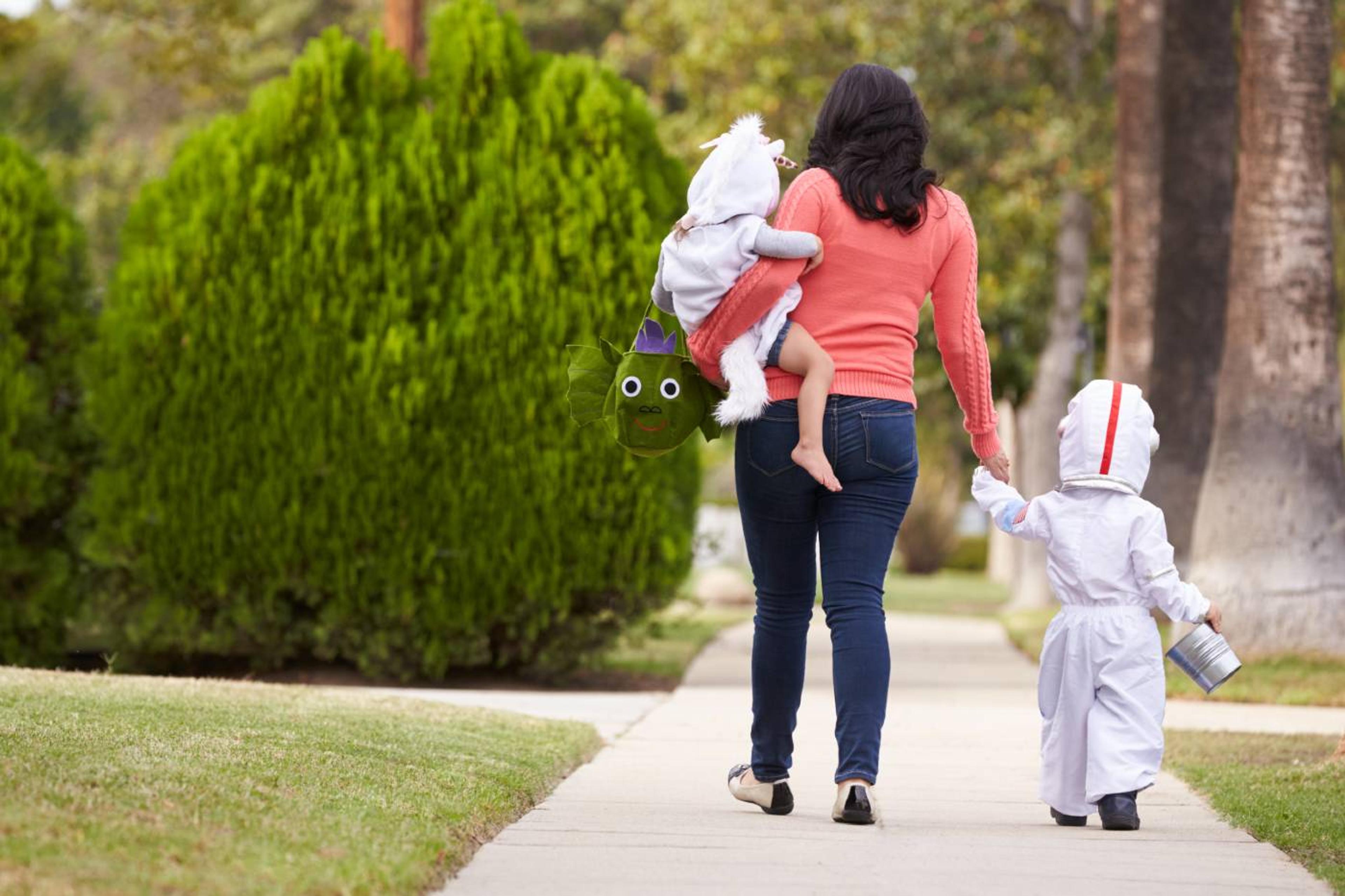 Mom trick-or-treating with baby and toddler on Halloween