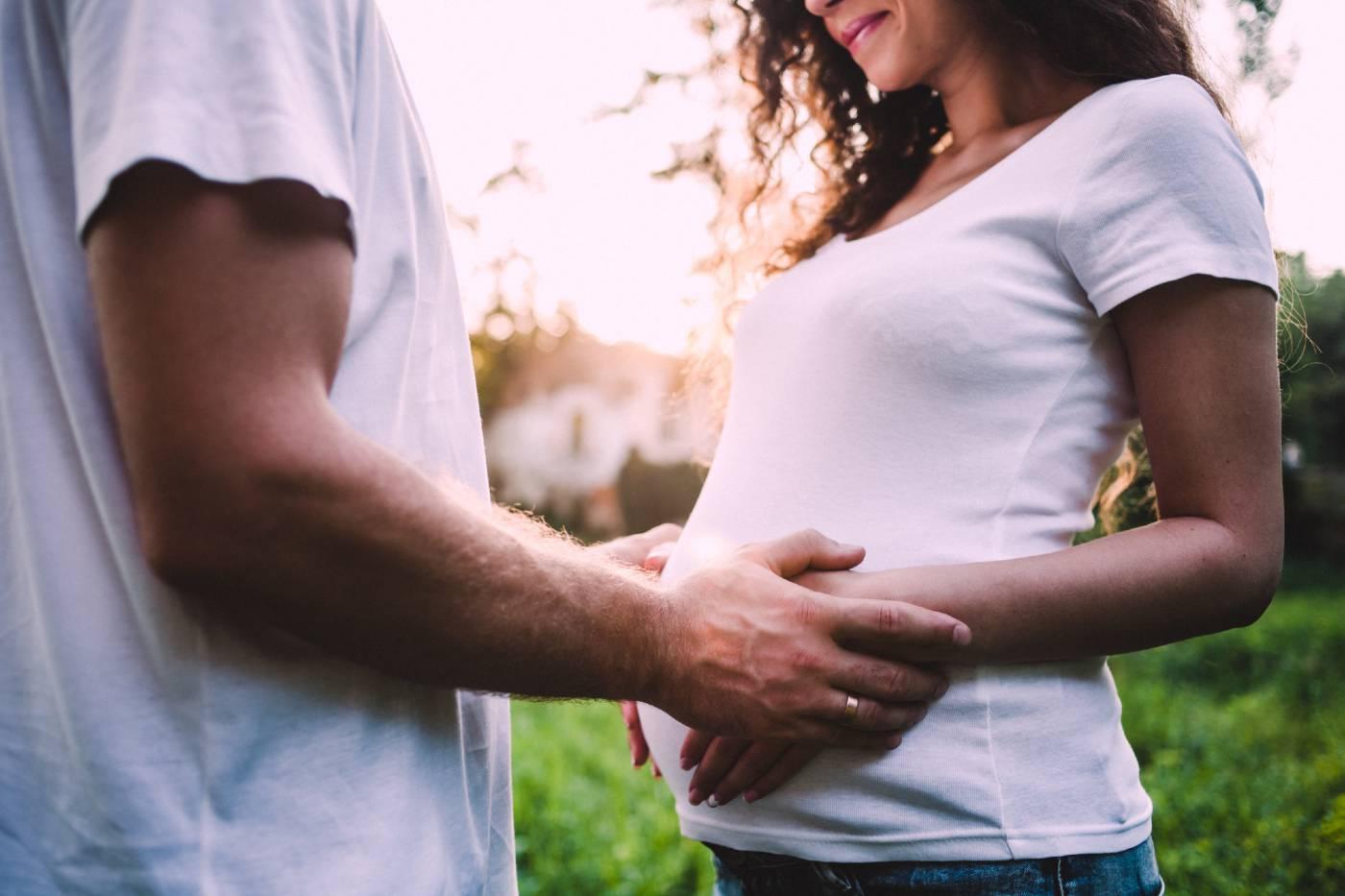 A husband cradles his wife's pregnant belly