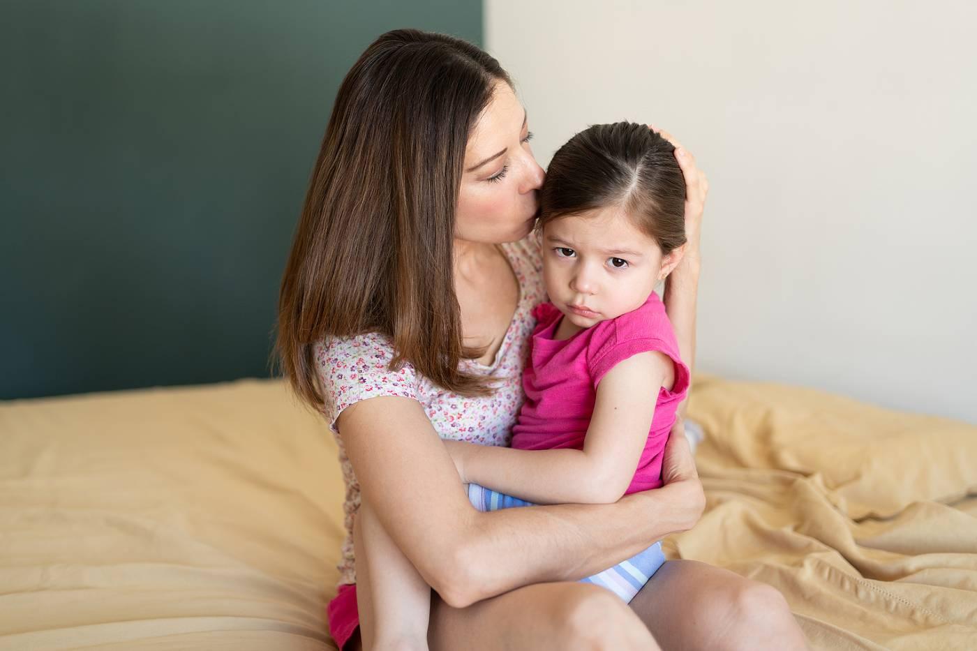 mom comforting child who wet the bed
