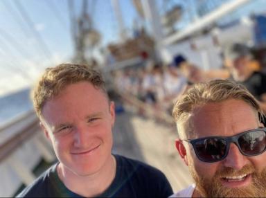 Victor Andre Landsvik på båt sammen med kapteinen.