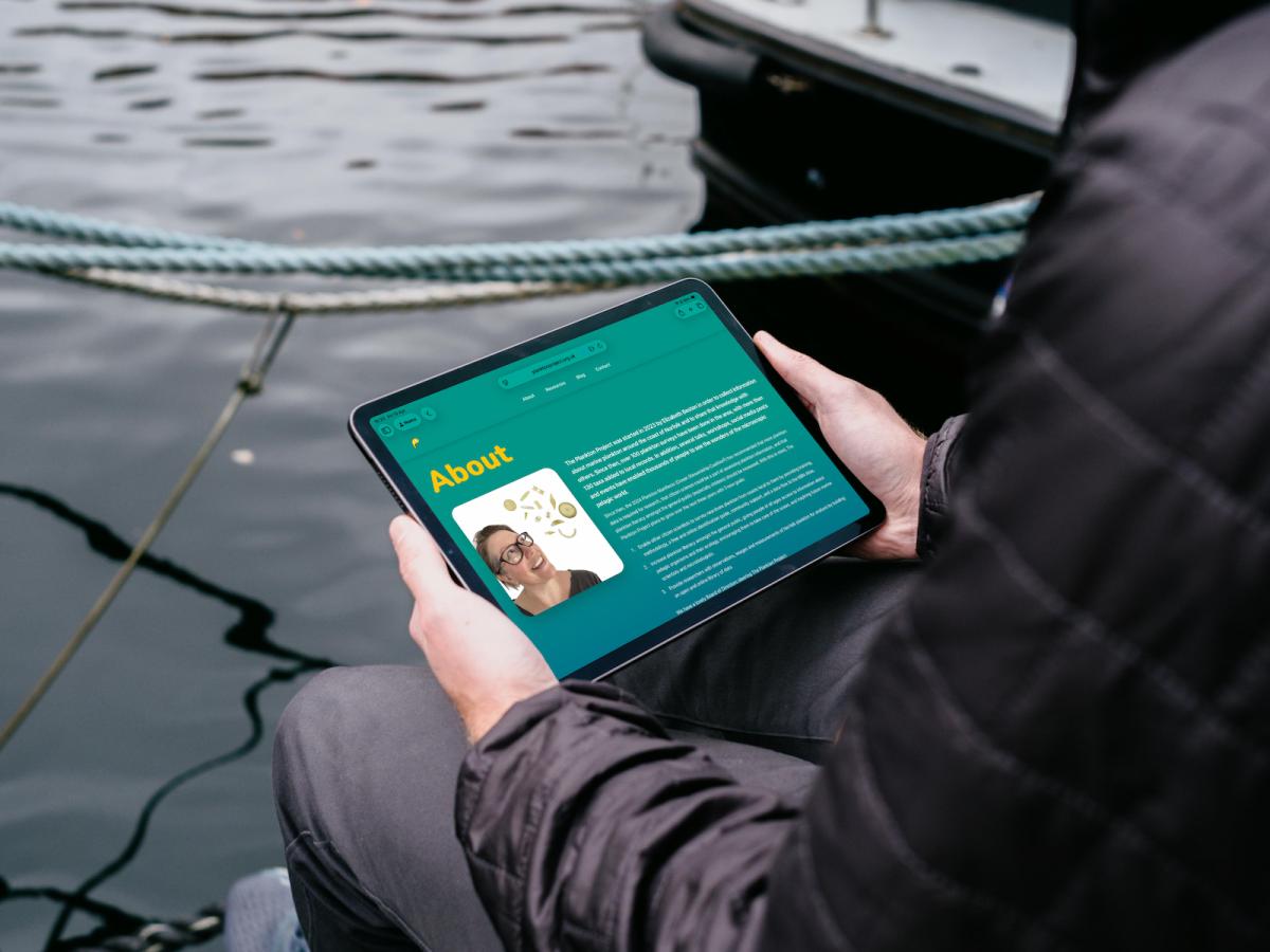 An image of someone holding an iPad looking at the Plankton Project website