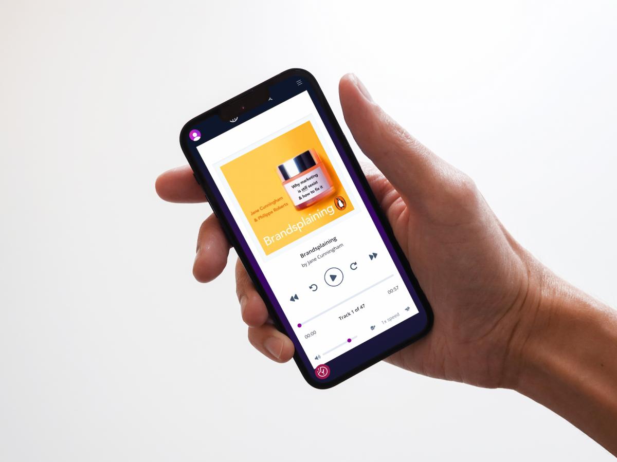 An image of someone holding a mobile phone, using the built-in streaming app