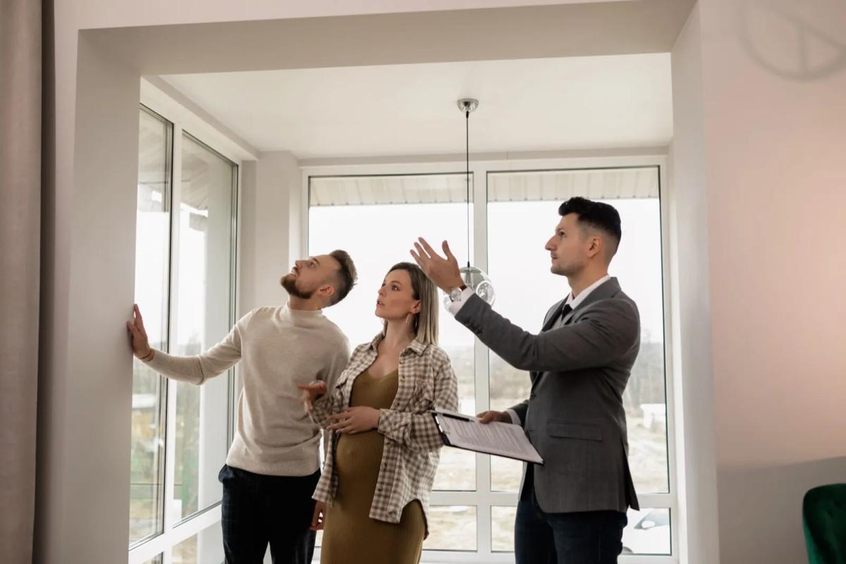 Couple inspectant l'état des murs d'un appartement pendant une visite
