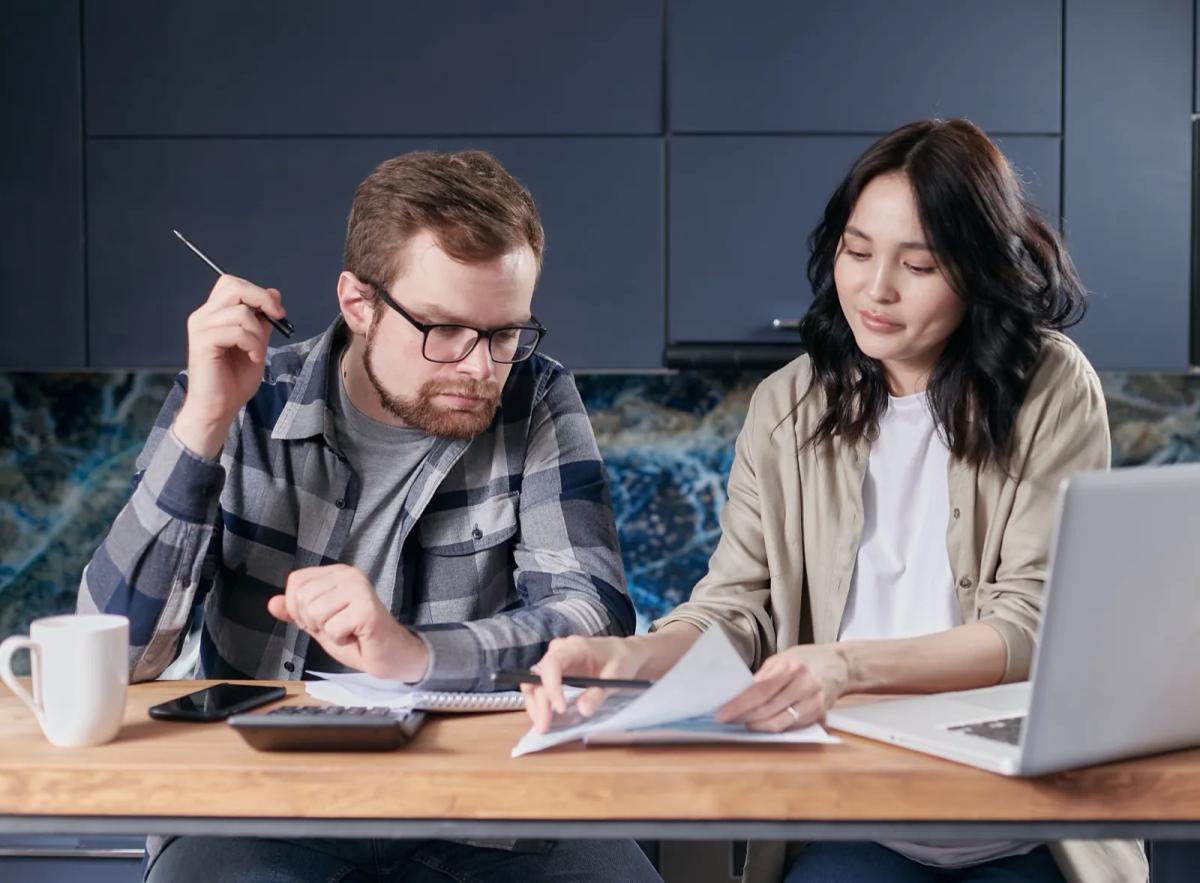 Couple examinant ensemble ses documents budgétaires et son loyer à la maison