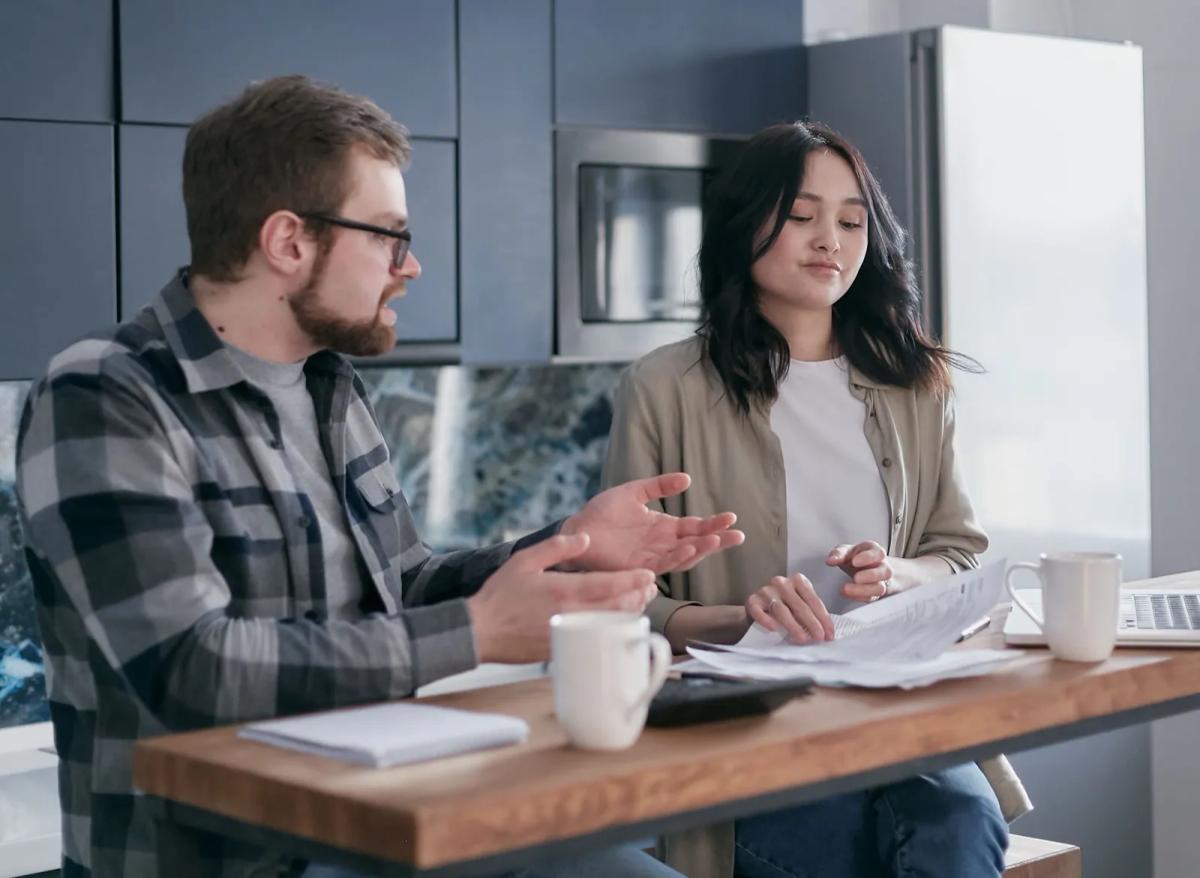 Locataire et propriétaire en désaccord lors d'un état des lieux dans un appartement