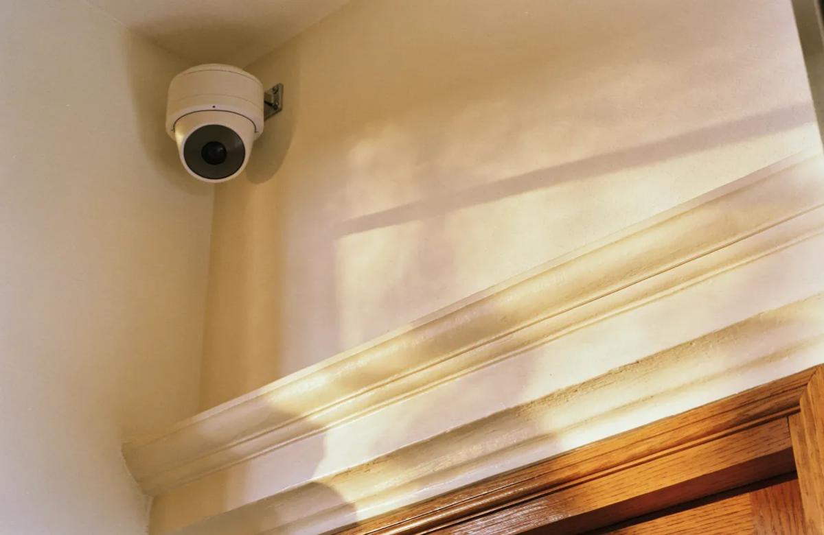 Caméra de surveillance intérieure fixée dans l'angle d'un salon lumineux
