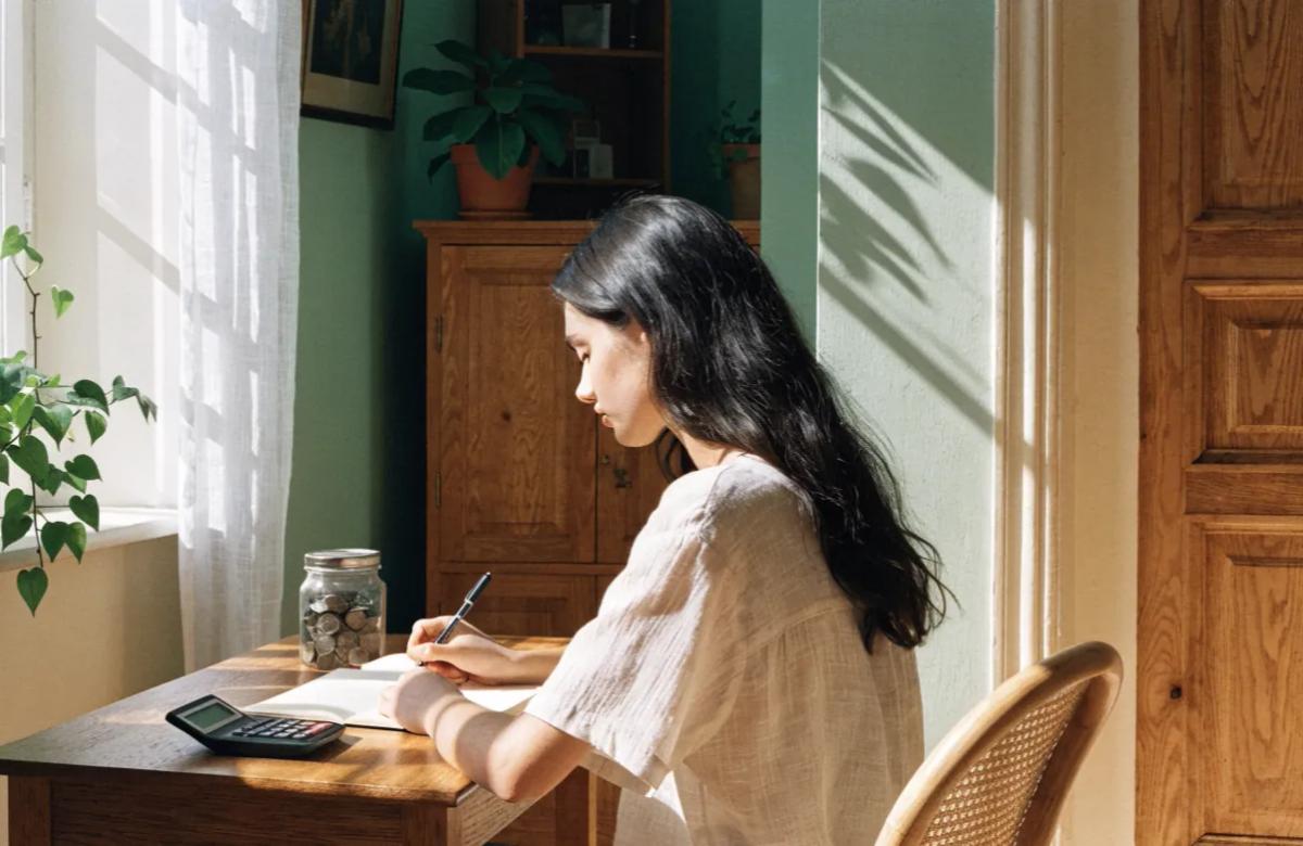 Jeune adulte préparant son projet de premier appartement, carnet et budget en main