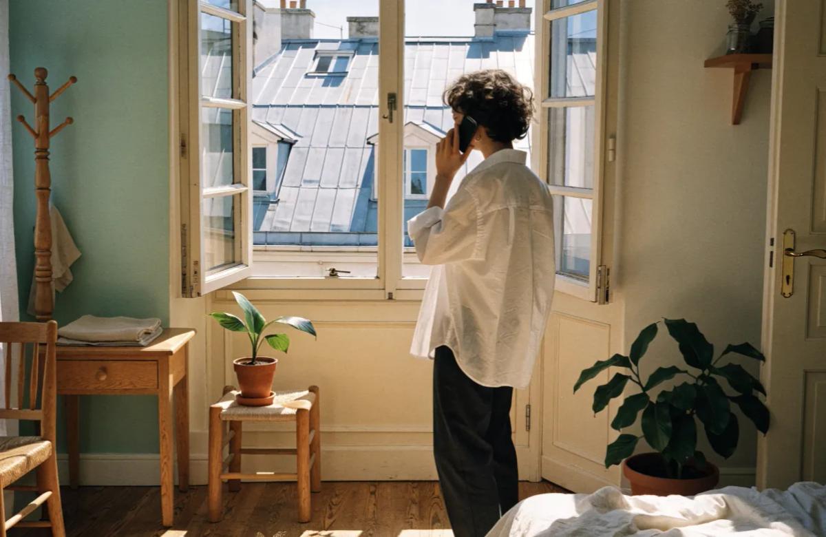 Jeune locataire réalisant l'état des lieux d'entrée d'un appartement avec son smartphone