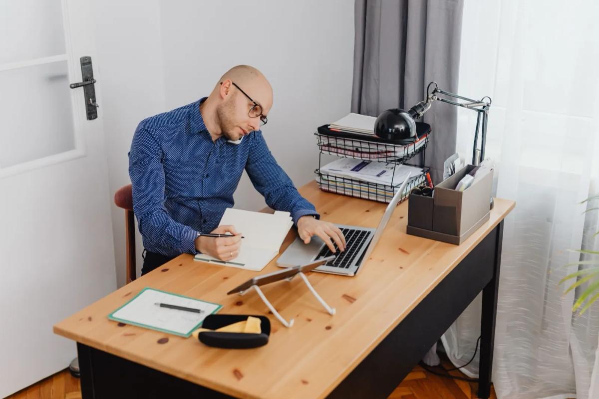 Entrepreneur travaillant sur son ordinateur portable à son domicile pour gérer le siège social de son entreprise