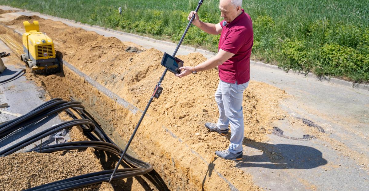 Géomètre-expert posant une borne sur un terrain lors d'une opération de bornage