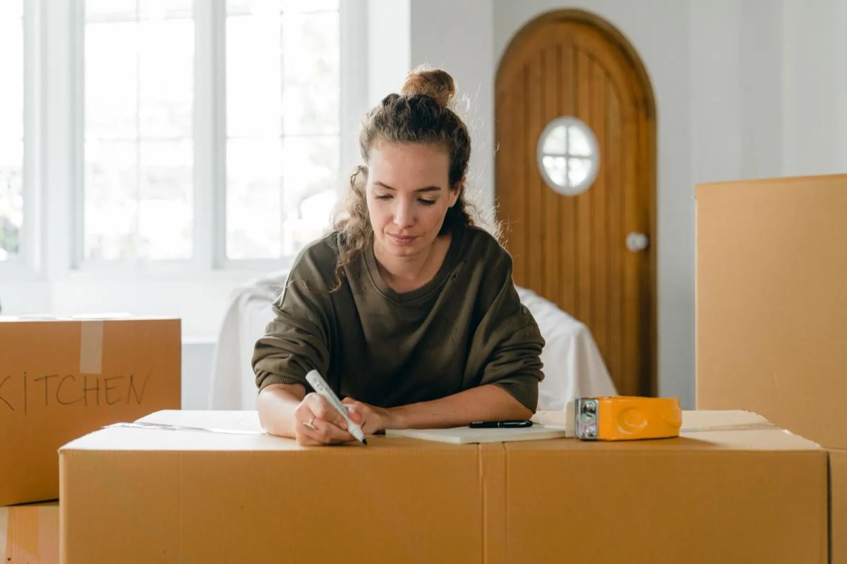 Cartons de déménagement empilés et factures pour la demande de prime CAF