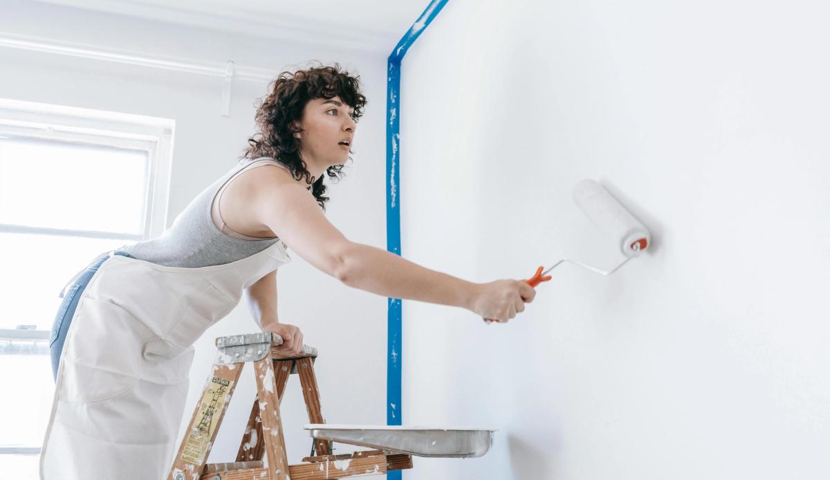 Locataire en train de peindre un mur de son appartement