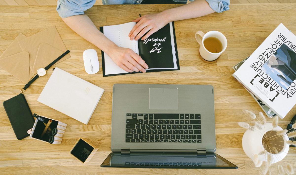 Personne rédigeant une lettre de motivation de location sur son ordinateur