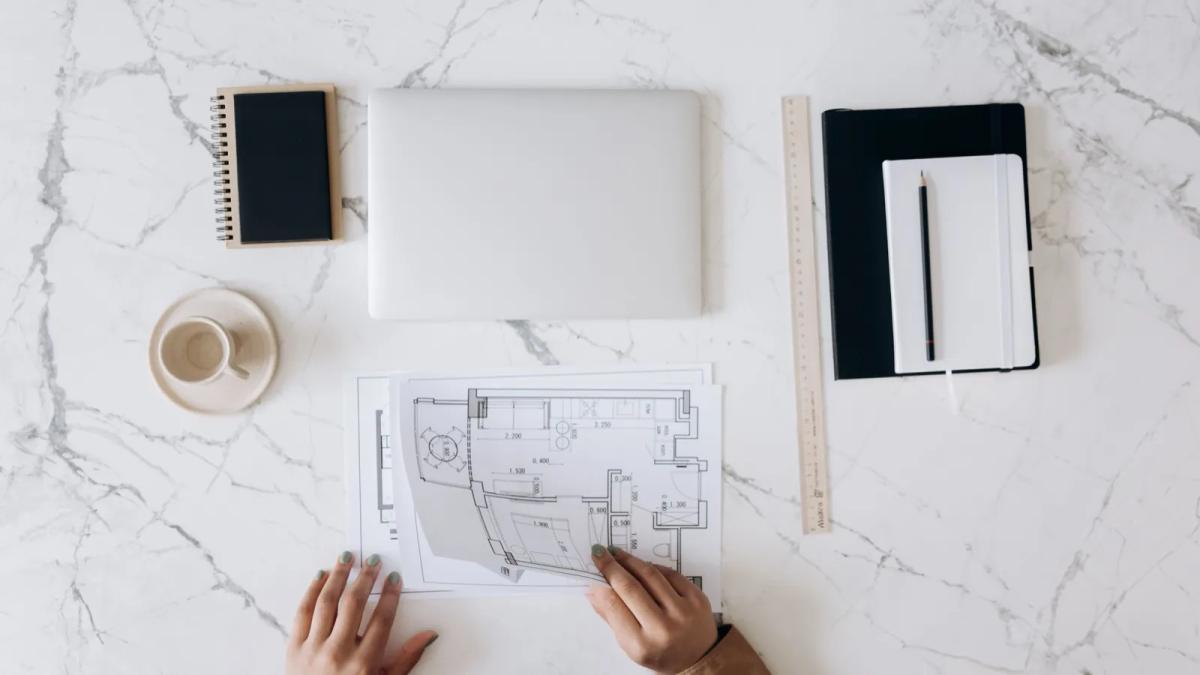 Dossier technique de travaux en copropriété avec plans et devis posés sur une table