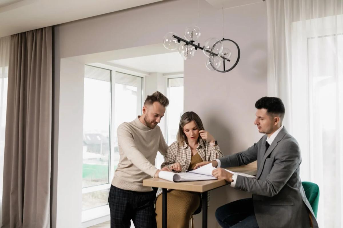 Couple signant un acte de rachat de parts immobilières chez le notaire