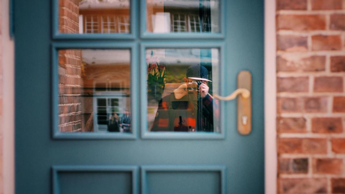 Locataire documentant un squat avec son téléphone devant la porte de son appartement