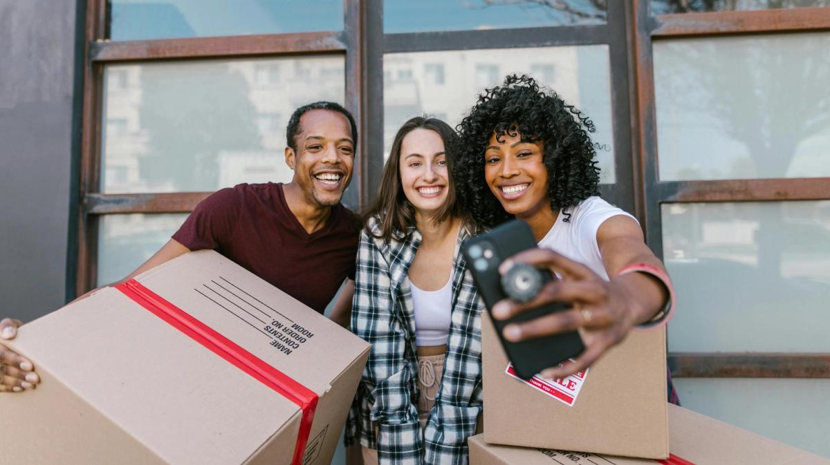 Groupe d'amis portant des cartons lors d'un déménagement