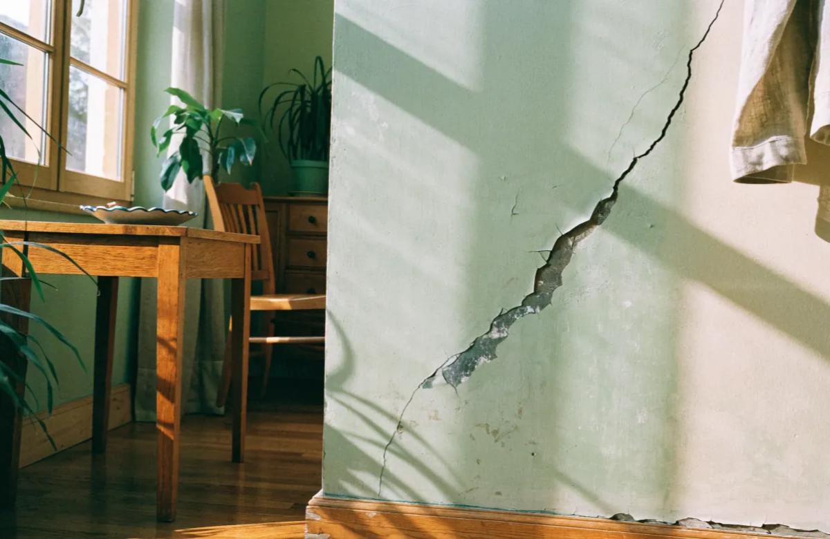 Mur abîmé et peinture arrachée dans un logement après le départ du locataire