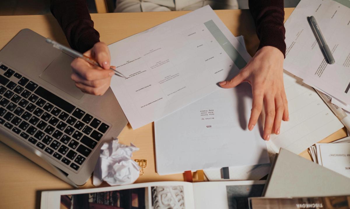 Freelance face à une pile de documents pour constituer son dossier de location