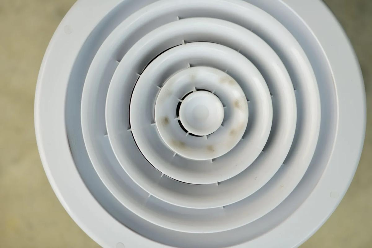 Bouche d'extraction de VMC au plafond d'une salle de bains