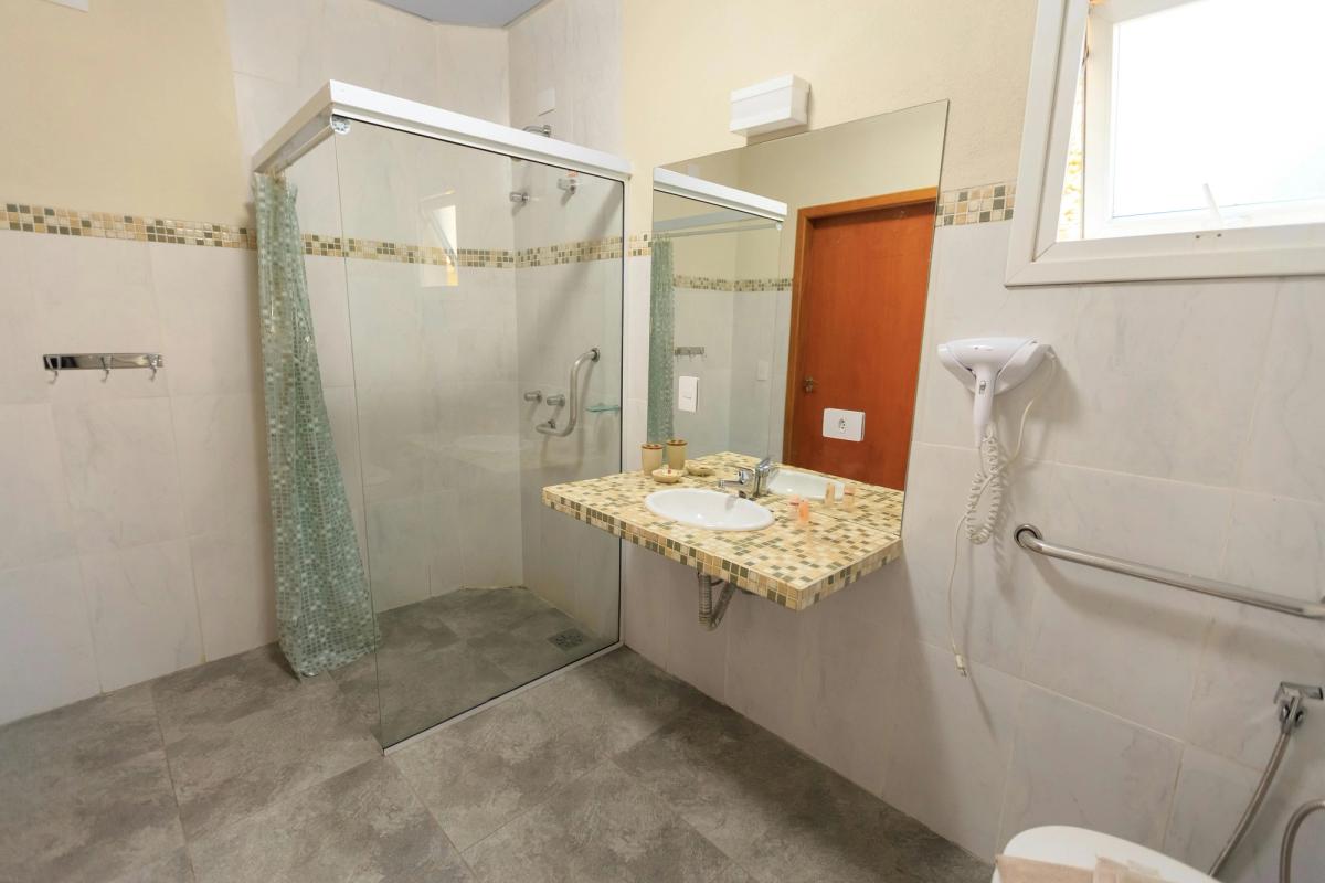 Salle de bain PMR avec douche à l'italienne, barres d'appui et espace de manœuvre en fauteuil roulant