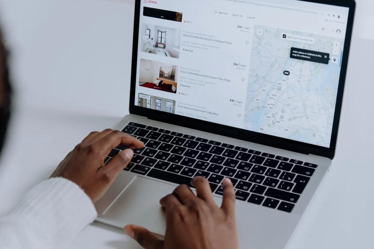 Personne consultant des annonces de location d'appartement sur son ordinateur portable